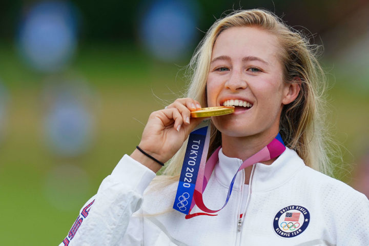 Gold medallist USA's Nelly Korda bites her medal on the podium during the victory ceremony of the womens golf individual stroke play during the Tokyo 2020 Olympic Games at the Kasumigaseki Country Club in Kawagoe on August 7, 2021. (Photo by YOSHI IWAMOTO / AFP) (Photo by YOSHI IWAMOTO/AFP via Getty Images)