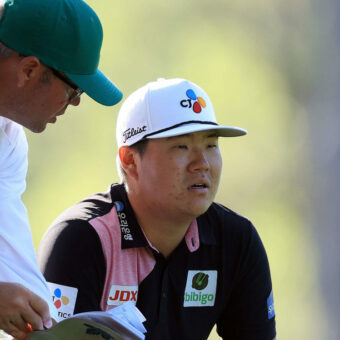 AUGUSTA, GEORGIA - APRIL 07: Sungjae Im of South Korea and caddie William Spencer line up a shot on the 14th hole during the first round of the Masters at Augusta National Golf Club on April 07, 2022 in Augusta, Georgia. (Photo by David Cannon/Getty Images)