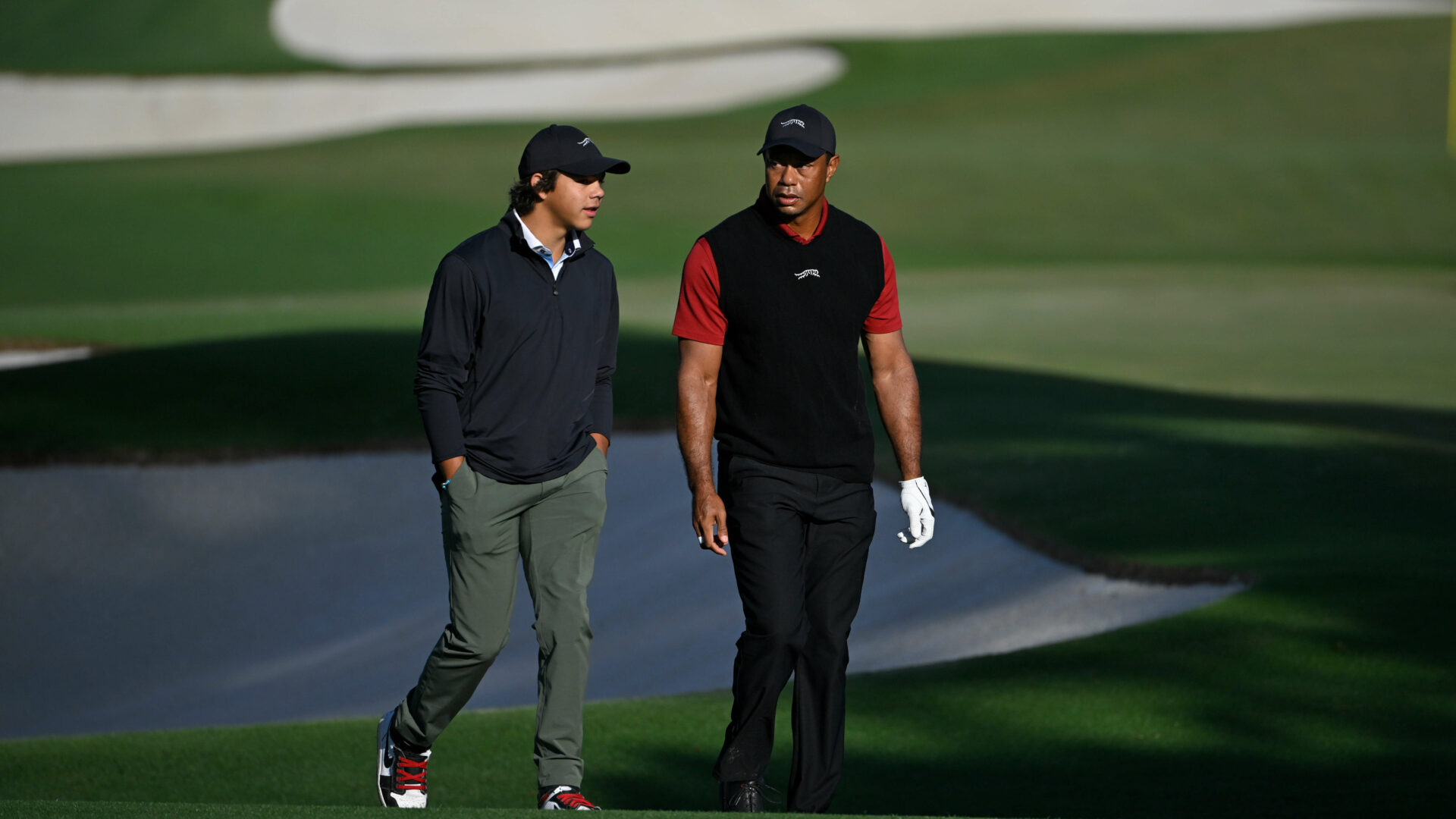 AUGUSTA, GEORGIA - APRIL 14: Tiger Woods with his son Charlie as he makes his way around the practice range for the final round of Masters Tournament at Augusta National Golf Club on April 14, 2024 in Augusta, Georgia. (Photo by Ben Jared/PGA TOUR via Getty Images)